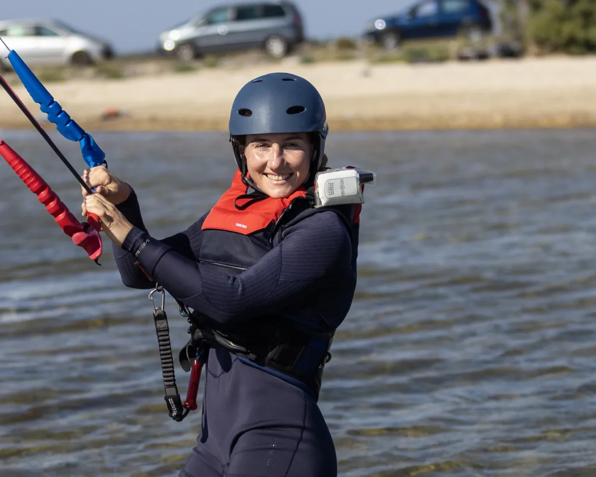Une élève souriante, casque et talkie-walkie, la barre en main dans le lagon