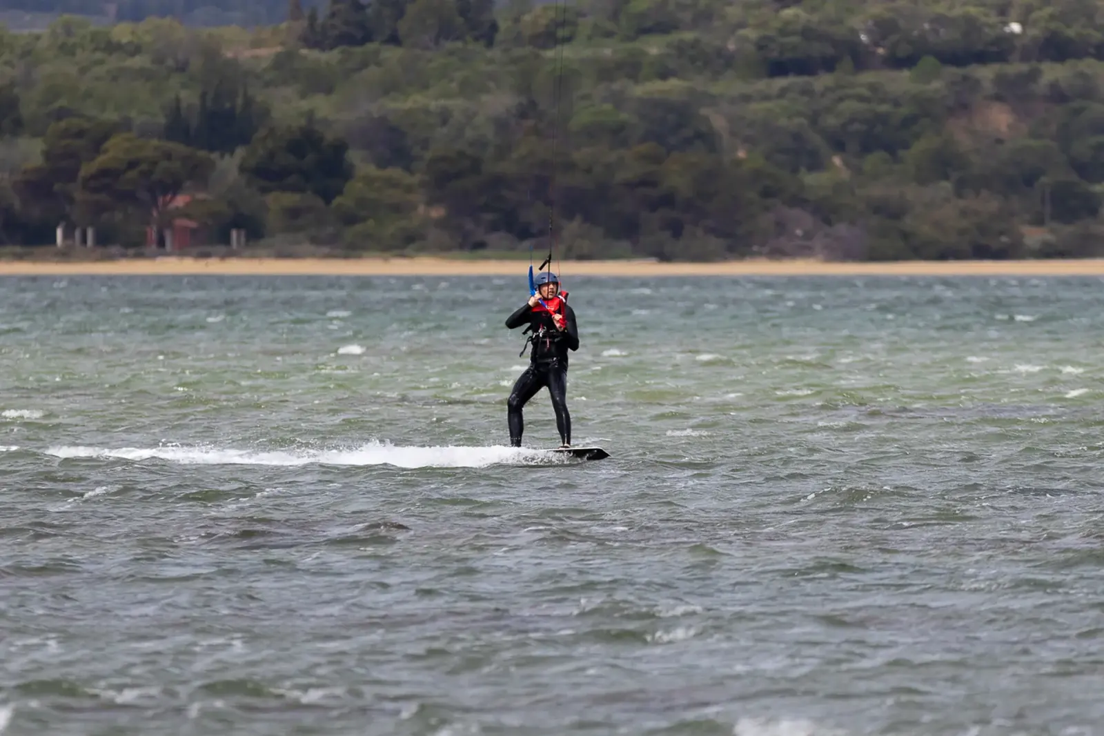 Un élève en navigation sur le lagon de La Palme, la garrigue en arrière-plan